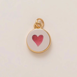 Minimalist round gold charm with white enamel surface and a pink heart pattern