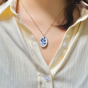 Retro 18K gold plated necklace with oval blue floral ceramic pendant worn by model