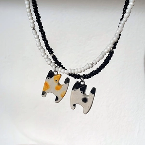 Detalle de collares de cuentas con colgantes de gatos de cerámica esmaltada brillante