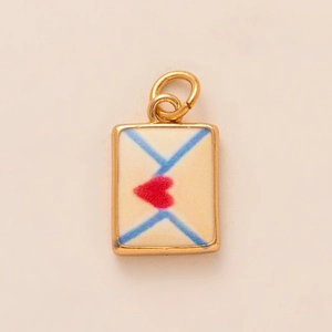 Golden envelope pendant with white enamel surface and small red heart detail
