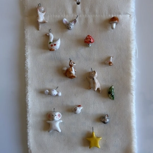 Collection of forest-themed ceramic animal pendants including squirrel and swan charms.