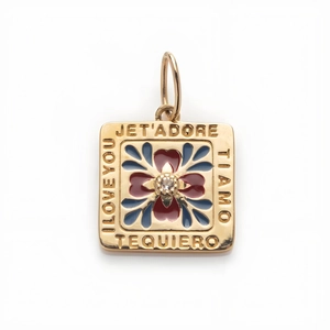 Macro detail of 14k gold square pendant with zircon flower and I Love You engravings