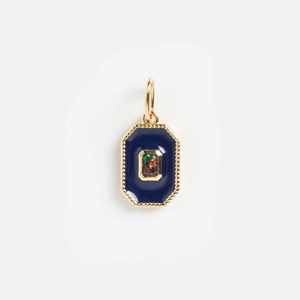 Detailed macro view of 14k gold geometric pendant with blue enamel and opal gemstone