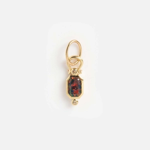 Macro shot of a rectangular black opal pendant with red fire and 14k gold diamond accents