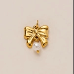 Close-up of golden bow pendant with white pearl drop for DIY jewelry making