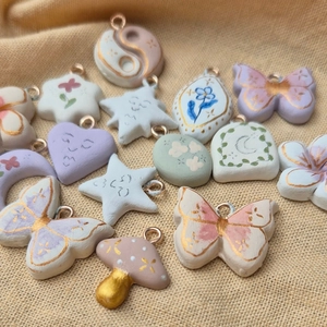 Detail of colorful hand-painted flower and butterfly charms with gold trim for DIY jewelry