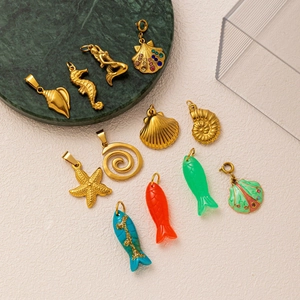 Ciondoli marini in acciaio dorato 18k con conchiglie colorate e soggetti marini assortiti