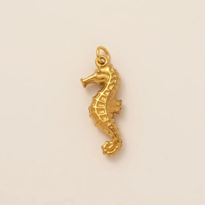 Macro di un ciondolo a forma di cavalluccio marino in acciaio inossidabile placcato oro 18K