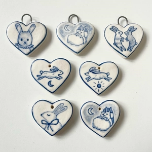 Set of heart-shaped blue and white ceramic pendants with artistic rabbit illustrations