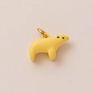 Detalle de un colgante de oso polar amarillo brillante con un aro de metal dorado