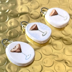 Three handmade ceramic pendants with martini glass illustration on gold background