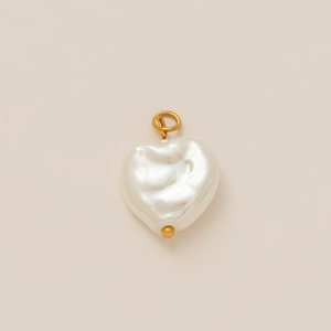 Pendente cuore di perla barocca con gancio placcato oro 18K su sfondo beige chiaro