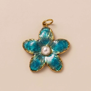 Detail eines blumenförmigen Anhängers mit türkisfarbenem Emaille und Perle