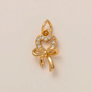 Elegante colgante de corazón y lazo bañado en oro de 18K con incrustaciones de circón