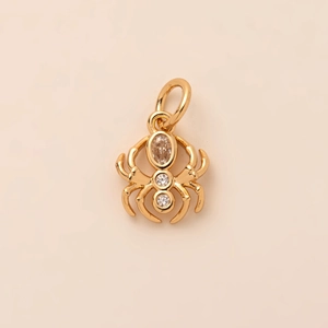 Macro-opname van gouden spin-hanger met bruine edelsteen en witte kristalaccenten