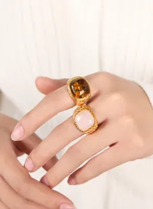 Detail of woven gold rings featuring natural tiger eye and pink quartz stones