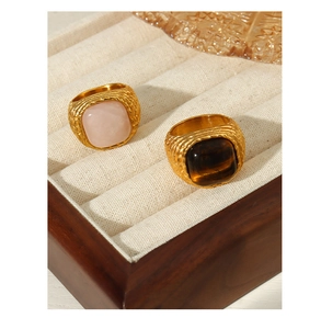 Detail of vintage woven titanium steel rings with pink gemstone and brown tiger eye stone