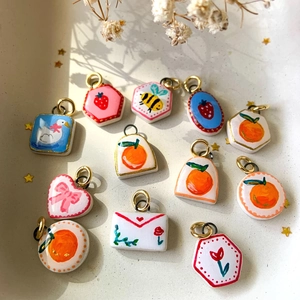 Bunte handbemalte Anhänger mit Erdbeeren und Schwänen mit goldenen Aufhängeschlaufen