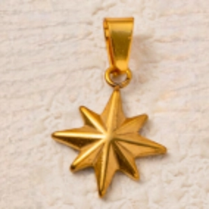 Primer plano de un colgante de estrella de ocho puntas en acero dorado sobre fondo