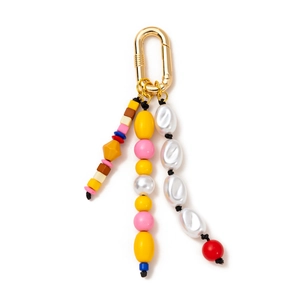 Dettaglio di ciondolo per borsa boho colorato con anello a D oro e perle barocche