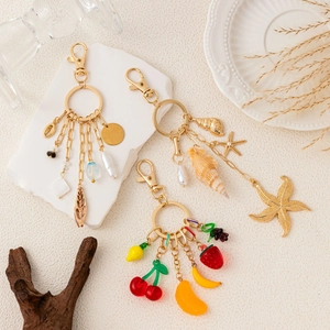 Detail of DIY keychains with 14K gold-plated starfish, shells, and vibrant fruit charms