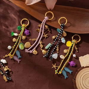 Detail of colorful woven ocean charms with golden seahorse, starfish and shell pendants