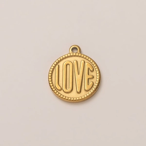 Primer plano del colgante redondo de metal dorado con texto LOVE y borde con textura