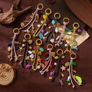 Retro colorful ocean-themed keychains with seashells and starfish on brown suede