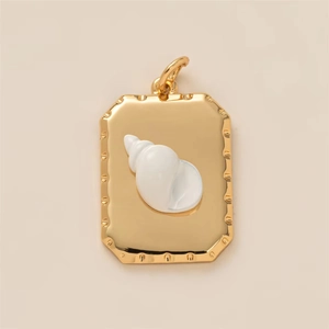 Vue détaillée d'un pendentif en coquillage plaqué or avec finition en émail blanc chic