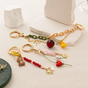Detail showing DIY keychain set with colorful charms, acrylic chains and metal clasp