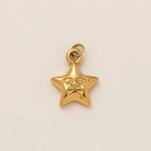 Detail of gold star pendant with anthropomorphic face relief and polished metal finish
