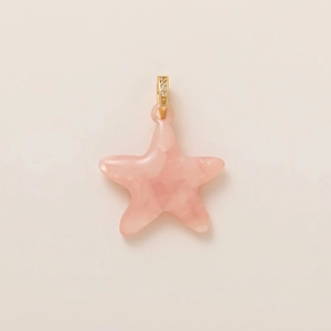 Détail d'un pendentif étoile rose avec monture dorée et cristaux scintillants