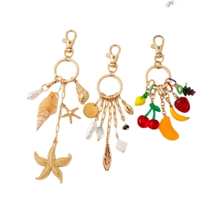 DIY 14K gold plated keychain with ocean charms, pearls, and fruit pendants on white back