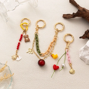 DIY fashion keychains with cute bear charms, red beads, and golden accessories for bags