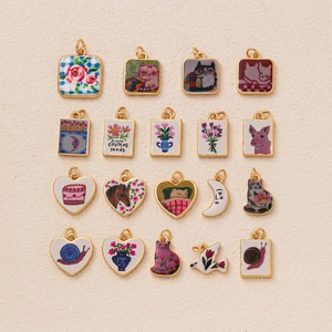 Flache Ansicht handbemalter Messinganhänger mit Katzen- und Blumenmotiven für Schmuck