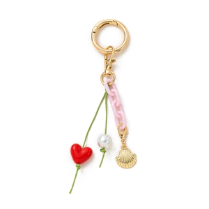 Detail of DIY keychain with gold ring, pink chain, red heart and pearl charm pendants