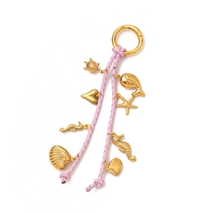 Close-up of pink woven leather keychain with gold marine pendants like sea turtles and dolphins