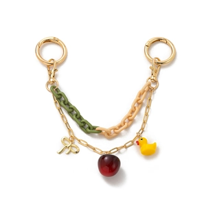 Detail of DIY bag charm featuring gold chains, resin links, and cute charms