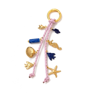 Detailed close-up of ocean-themed charm with pink woven leather and golden marine charms