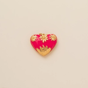 Detail van een roze hartvormige hanger met gouden madeliefjes en metalen oogje