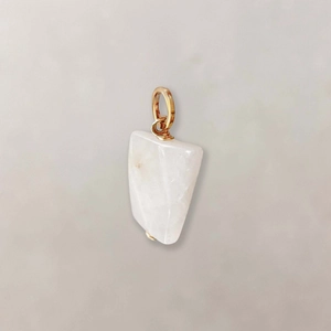 Detail macro-opname van een onregelmatige ovale witte stenen hanger met gouden draad