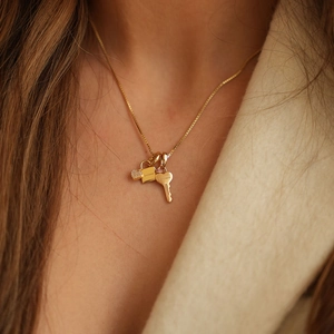 Gold stainless steel soulmate necklace with heart and key pendants on a female model