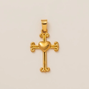 Vista macro del colgante de cruz chapado en oro 18K con corazón central y motivos de volutas
