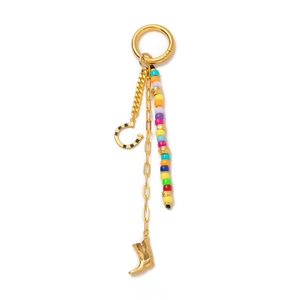 Detail of bohemian gold keychain with colorful beads, metal boot and horseshoe charms