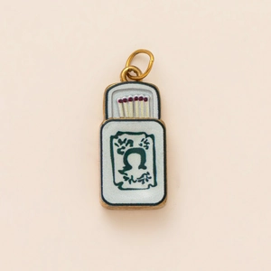 Detailansicht eines Vintage-Streichholzschachtel-Anhängers mit rotem Kopf in Gold
