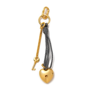 Detail of woven rope keychain with gold heart lock and key charms on white background