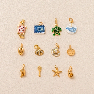 Collezione di 12 ciondoli marini dorati con tartarughe marine stelle e conchiglie
