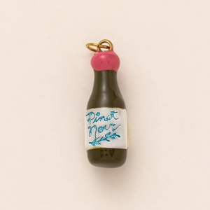 Detail of 18K gold-plated Pinot Noir wine bottle pendant with pink seal and black finish