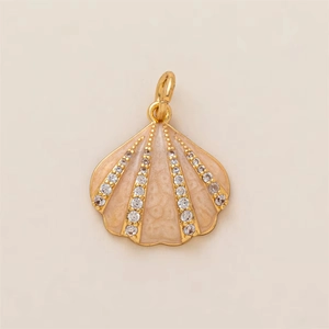 Macro detail of a golden scallop shell pendant with pink enamel and sparkling zircon rows