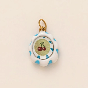 Macro detail of wave-edge cherry pendant in 18K gold plating with striped enamel